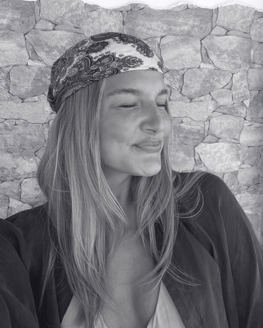 Carlotta lächelt mit geschlossenen Augen und legt den Kopf leicht schräg.